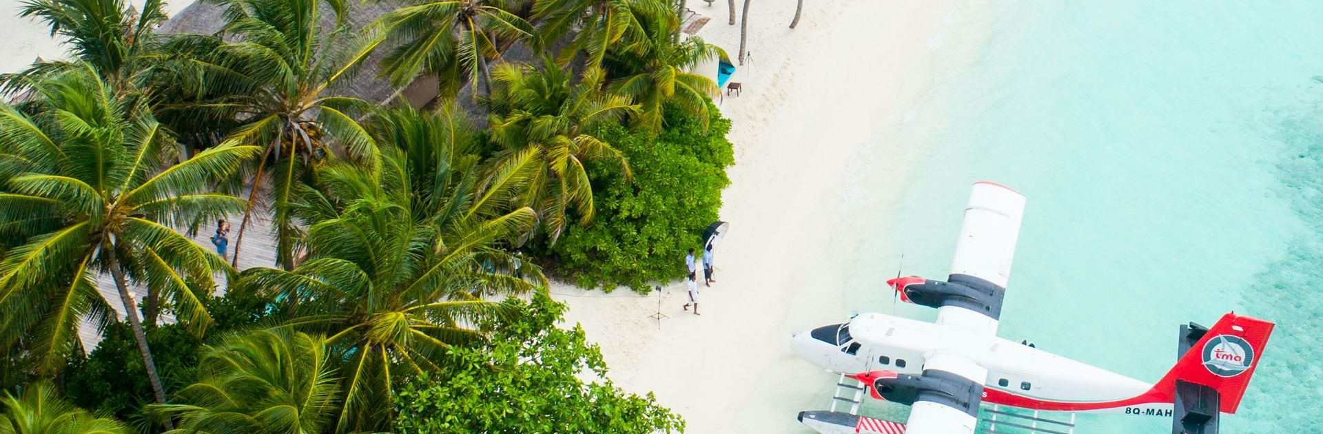 A seaplane on the sand beside a remote island resort